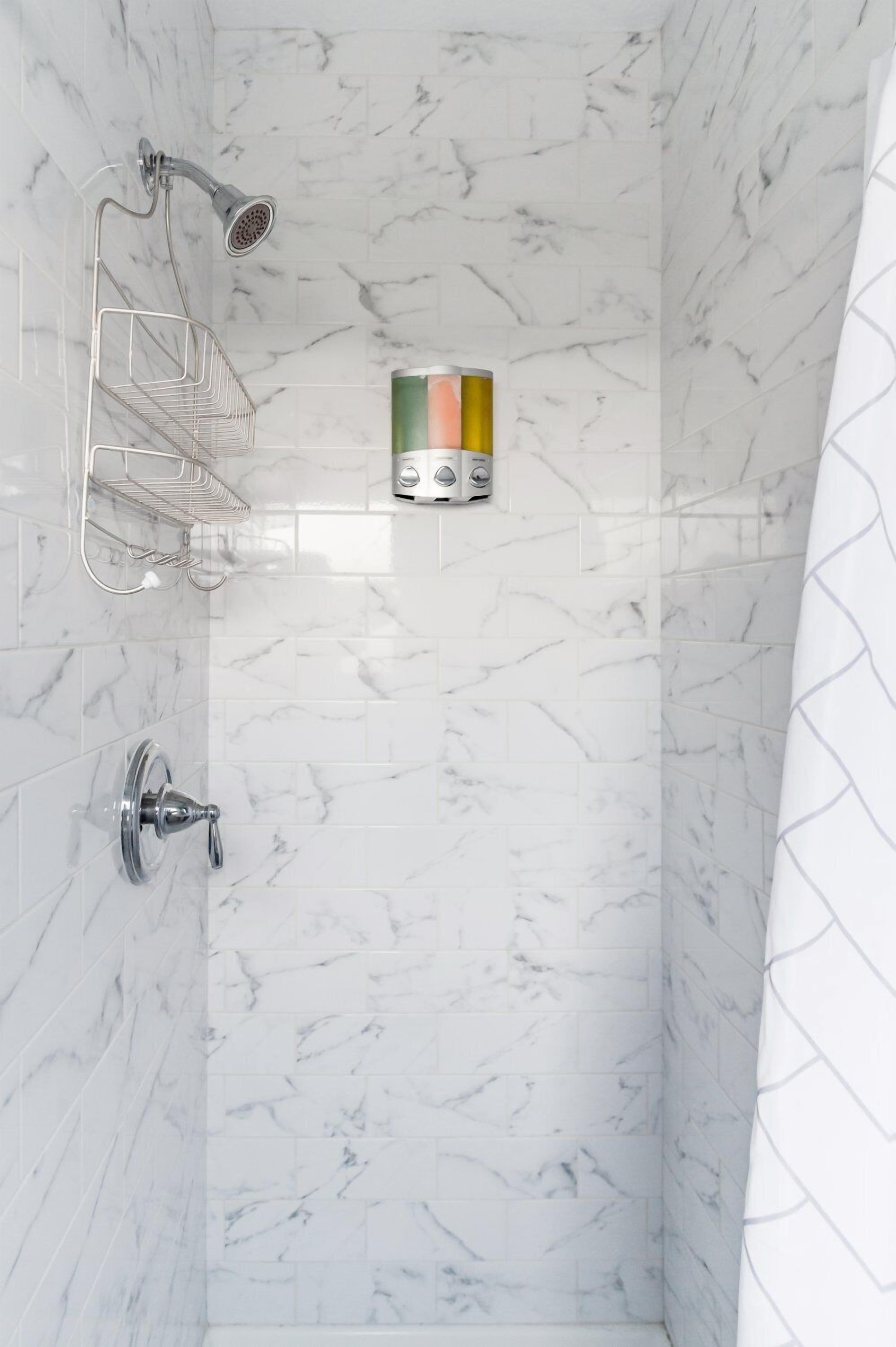 Eine Dusche mit Duschhandstück, Seifenspender an der Wand und einem Metallhandtuchhalter.