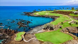 En golfbana med utsikt över havet och den steniga kustlinjen.