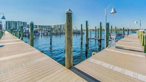 Eine hölzerne Pier, die sich über ein Gewässer erstreckt, mit blauem Himmel darüber.
