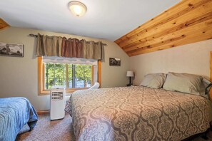 A bedroom with a bed, a window, a heater, and a lamp. - Private 100' Waterfront, 4BR - Heidaway Cottage (Sturgeon Bay)