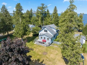 A house with a porch, a deck, and a view of the water. - Private 100' Waterfront, 4BR - Heidaway Cottage (Sturgeon Bay)