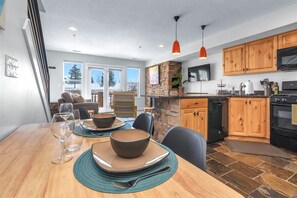 Enjoy meals in the kitchen and dining area with an oven and large windows offering a view of the outdoors.