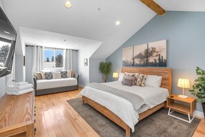 Relax in this serene bedroom with a large bed, bedside table, and window offering a view of the outdoors.