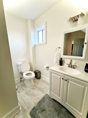 Een bad/douchecombinatie, een haardroger, handdoeken, zeep