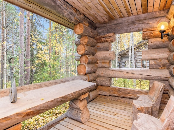 A log cabin interior with a wooden deck, a bench, and a table.