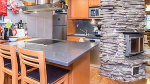Una cocina moderna con una pared de acento de piedra, electrodomésticos de acero inoxidable y armarios de madera.