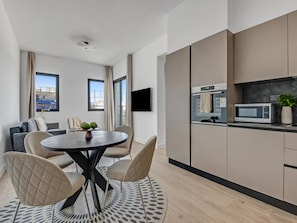 Enjoy a compact living space with a round dining table and four chairs, a microwave, and a small kitchen countertop.