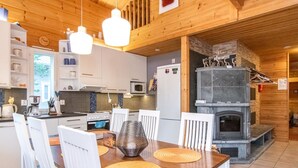 Une cuisine moderne avec des meubles blancs, un four à micro-ondes encastré et une cheminée en pierre.