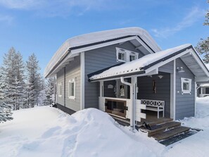 Een huis met twee verdiepingen, een overdekte veranda en een houten terras.