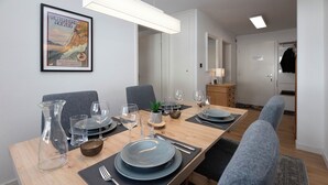 A dining area with a long table set for six, including plates, glasses, and cutlery. - Chalet zur Höhe by Interhome (Grindelwald)