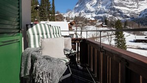 A balcony with a view of snow-covered mountains and a wooden deck. - Chalet zur Höhe by Interhome (Grindelwald)