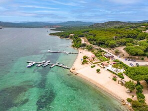 An aerial view of a coastal area with a marina, sandy beach, and lush greenery. - Vacation home Bolina by Interhome (Porto Pozzo)