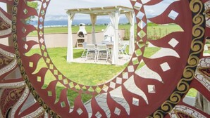 Un belvédère doté d’un espace barbecue, entouré d’une clôture décorative ornée d’un motif géométrique.