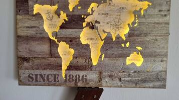 A wooden world map with 'OLD WORLD MAP' and 'SINCE 1886' text, mounted on a wall.