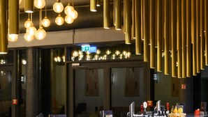 A modern interior with hanging spherical lights and vertical cylindrical fixtures. - Parkhotel Braunau  (Braunau am Inn)