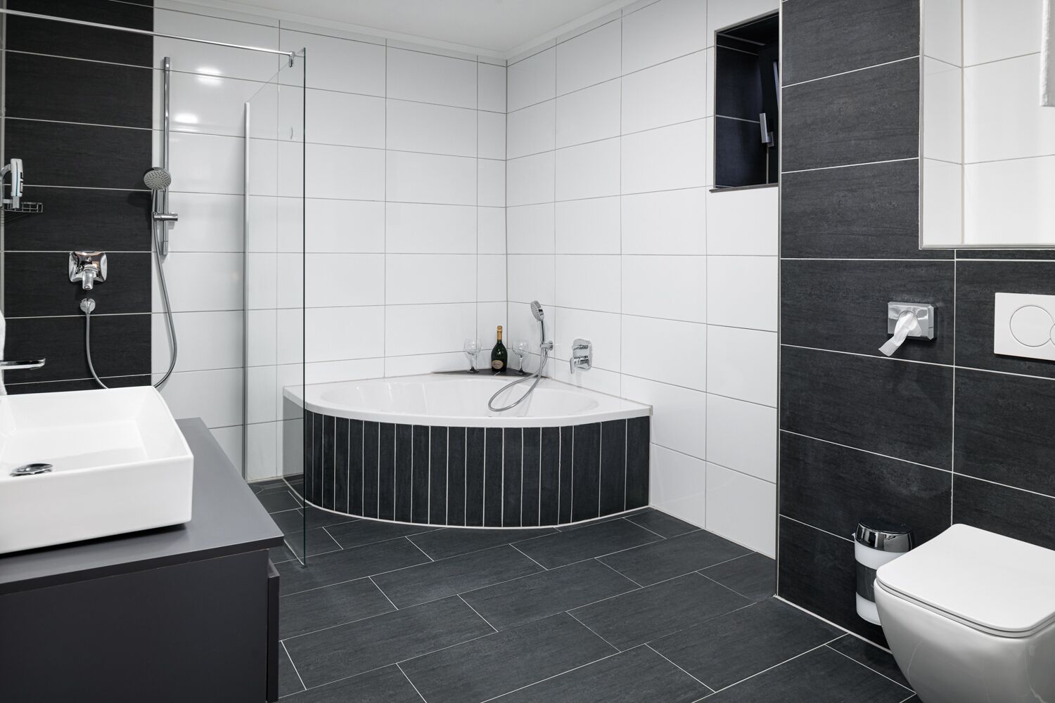 A modern bathroom with a freestanding bathtub, a large mirror, and a toilet.