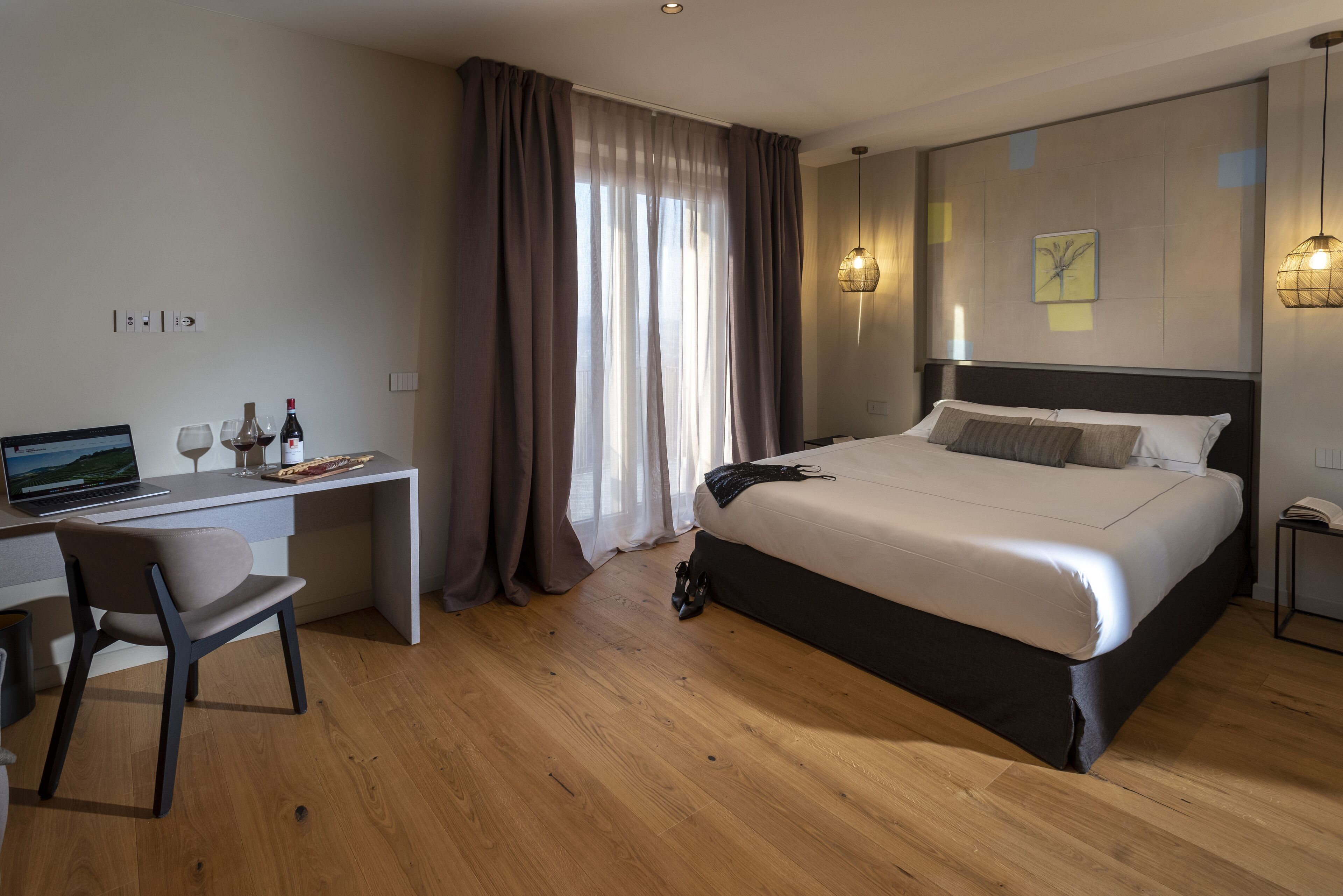 Een moderne hotelkamer met een bed, bureau en computer.