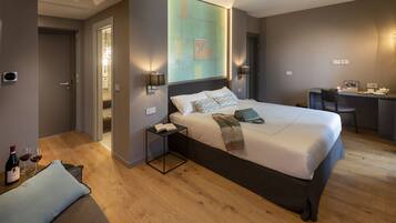 A modern hotel room with a large bed, bedside tables, a desk, and a chair.