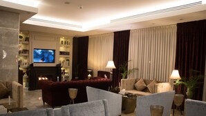 A modern living room with a fireplace, comfortable seating, and a flat-screen TV.