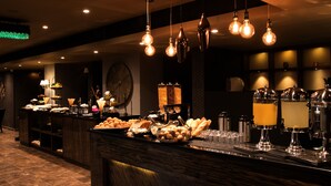A buffet area with various food items and a bar with drinks.