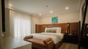 A hotel bedroom with a bed, bedside tables, a sofa, and a large window with curtains. -  Ambiance Boutique Art Hotel Karachi (Karachi)