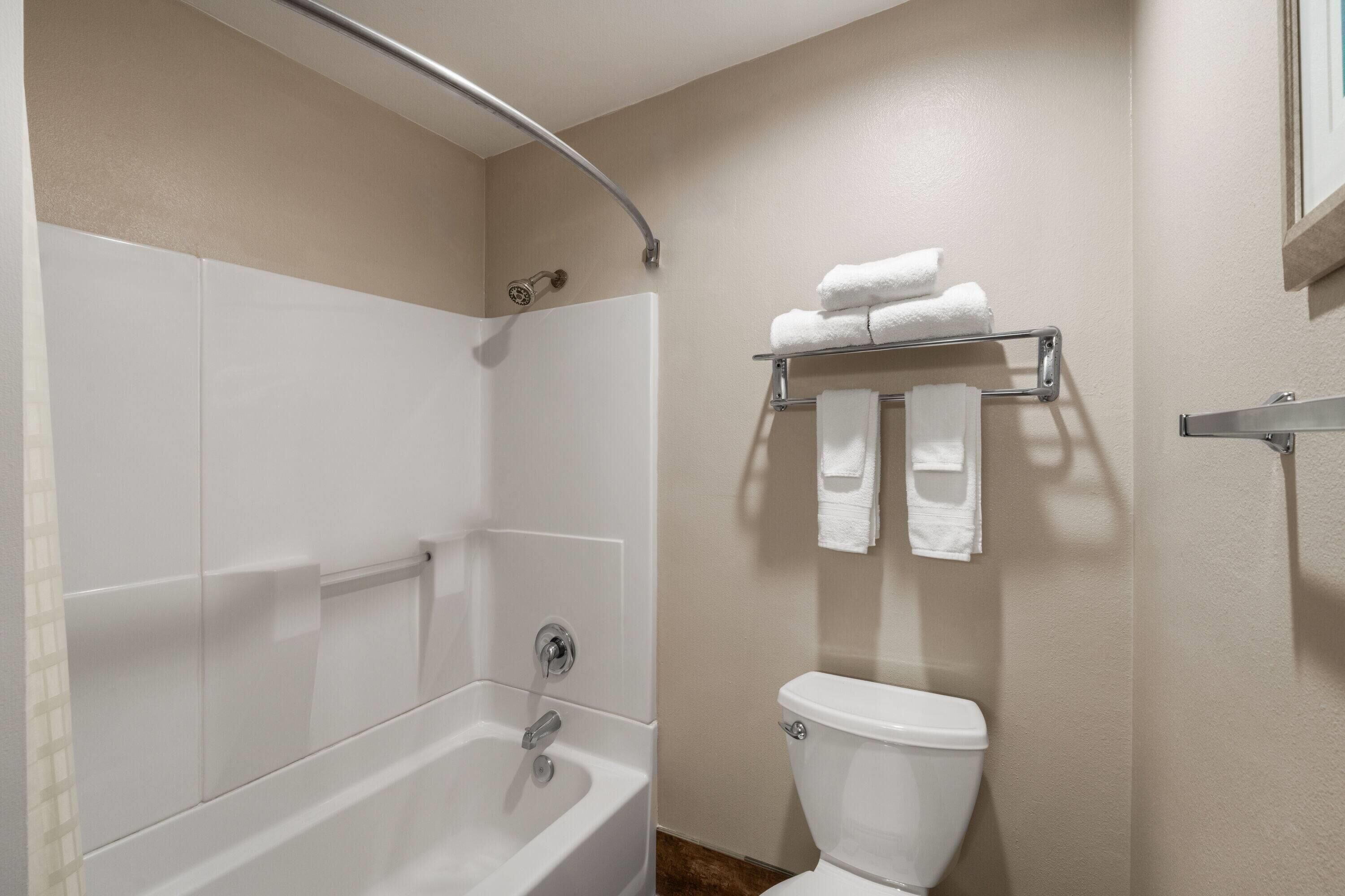 Un baño con bañera, inodoro y perchero para toallas.