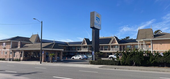 A Bayside Inn and Suites building with a parking lot and several cars parked in front.