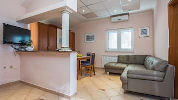 Family Apartment A2 | Oppholdsområde | En 100-centimeters Flatskjerm-TV med Parabol-TV samt TV