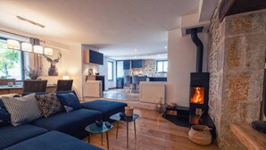Un salon moderne avec un canapé bleu, une cheminée et une cuisine en arrière-plan.