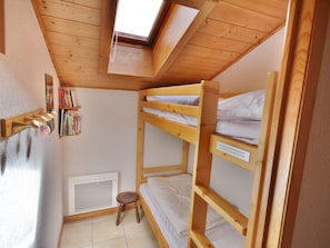 A bunk bed room with a skylight, a radiator, and a small stool. - Cozy Studio with Cabins, Close to Shuttles – Sleeps 4 (Morzine)