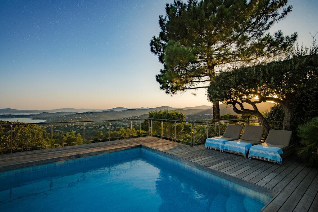 A swimming pool with lounge chairs and a view of the landscape.