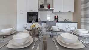 A modern kitchen with white cabinets, a stainless steel range hood, and a coffee maker. - Villa Nicolle (Privlaka)