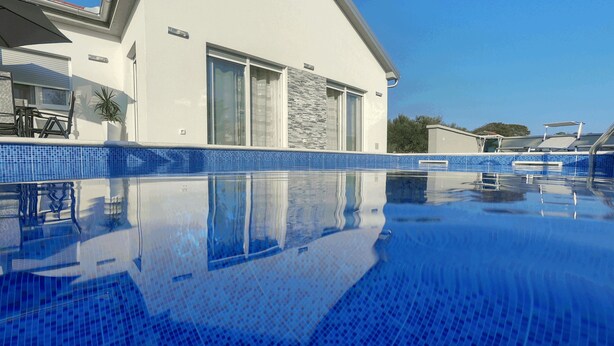 A modern house with a swimming pool, large windows, and a stone facade. - Villa Nicolle (Privlaka)