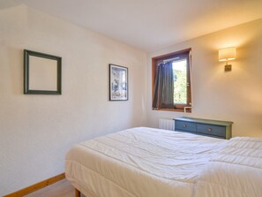 A bedroom with a bed, a dresser, a window with curtains, and two framed pictures on the wall. - Apartment Morzine 6 pers, near slopes, terrace, parking (Morzine)