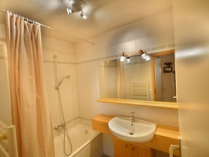 A bathroom with a shower, a bathtub, a sink, and a mirror.