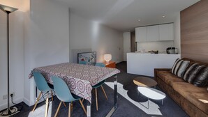 A modern apartment with a dining area, a living room, and a kitchen.