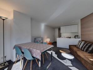 A modern apartment with a dining area, a living room, and a kitchen.