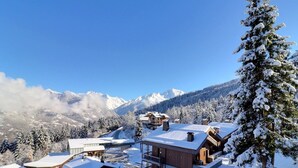 A snow-covered mountain resort with cabins and a ski lift. - Comfortable 2-Room, Ski-in/Ski-out, Close to Shops (La Tania)