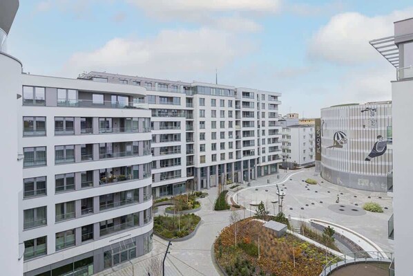 Un edificio moderno de varios pisos con un patio central, rodeado por otras construcciones.