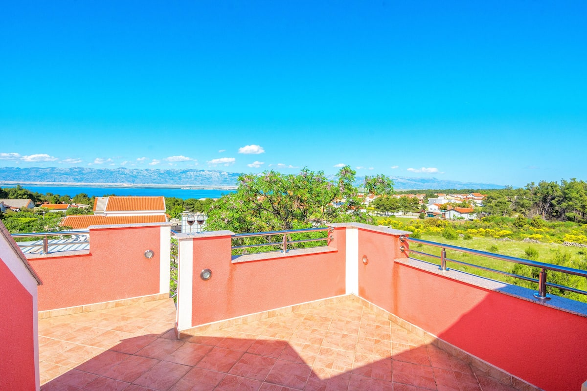 Una terraza en la azotea con vistas al mar y a las montañas.