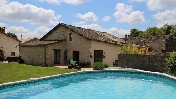Una piscina amb una casa al fons.