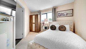 A bedroom with a large bed, a wardrobe, a vanity, and a window with curtains. - Tower Bridge Modern 2Bed 2Bath Apartment by London Bridge (London)