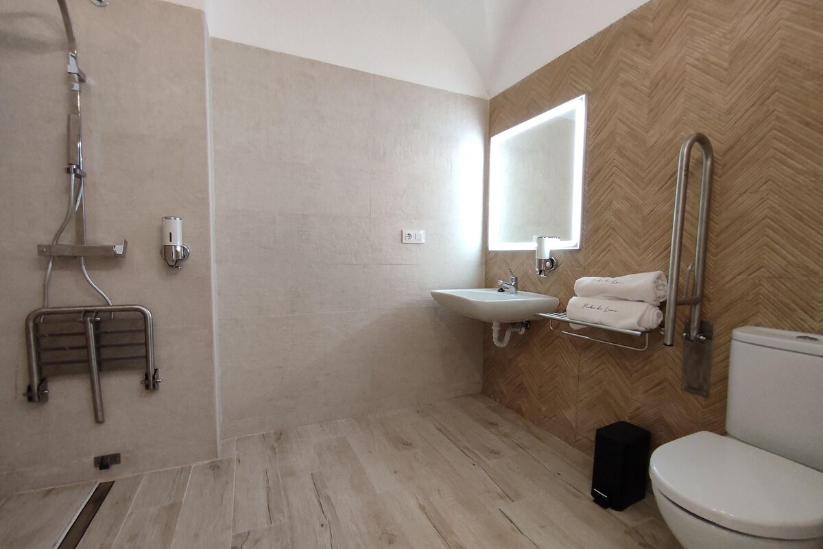 A modern bathroom with a shower, sink, and toilet.