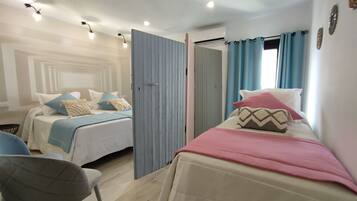 A bedroom with two beds, a chair, and an air conditioning unit.