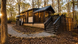 Een chalet met houten gevel, een stenen fundering en een trap naar de ingang.