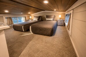 Een slaapkamer met twee bedden, een nachtkastje, een bedtafel en een raam met gordijnen.