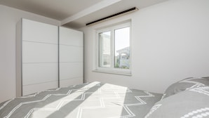 Un dormitorio con cama, ventana y armario.