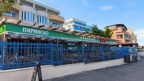 Ein Restaurant namens 'ПРИНИШКО PANORAMA' mit Außenbereich und einem blauen Zaun.