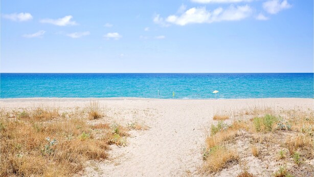 A sandy beach with a clear blue sky and calm sea. - Beautiful apartment in Sant'Antioco (Sant'Antioco)