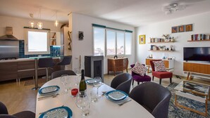 A modern living room with a dining area, a kitchen, and a TV area. - Beautiful apartment in Sant'Antioco (Sant'Antioco)
